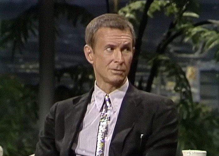 Hombre en traje oscuro durante entrevista televisiva, representando momentos de traición en Hollywood famosos.