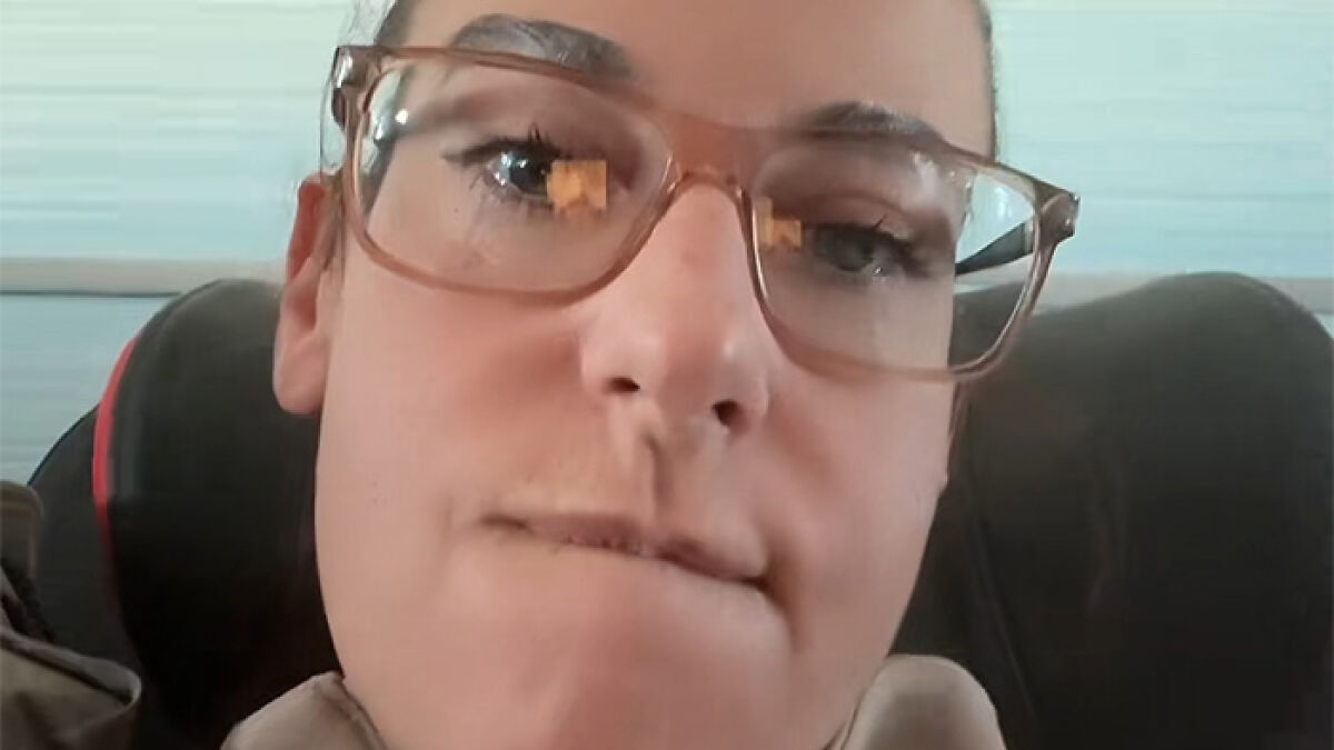 Pasajera de Air Canada con gafas y expresiu00f3n molesta durante vuelo criticando la comida ofrecida por la aerolu00ednea.