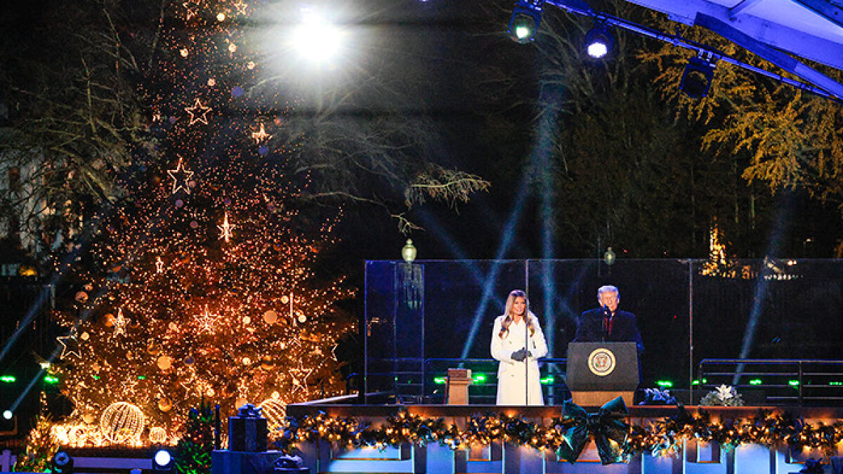 Melania Trump junto a un u00e1rbol de Navidad iluminado en evento navideu00f1o con actitud que genera reacciones diversas.