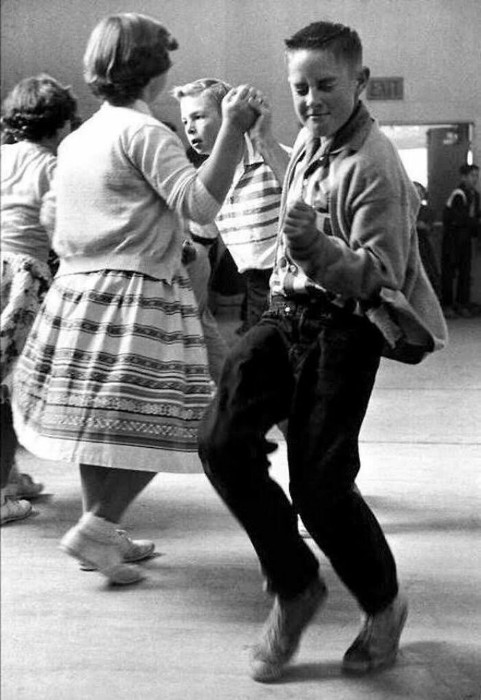Niños bailando en una tradicional fiesta escolar vintage, mostrando una escena que no veremos en la vida real hoy.