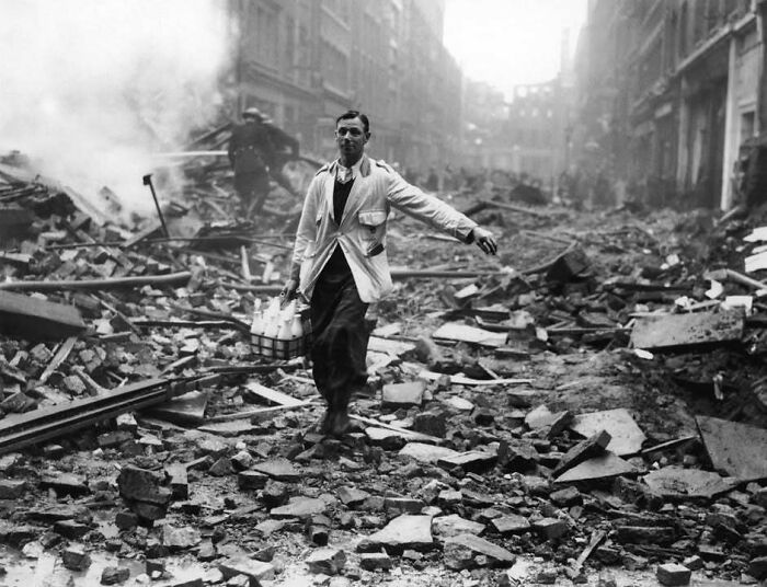 Hombre caminando entre escombros tras bombardeo, imagen histórica mostrando el mundo que nunca veremos en la vida real.