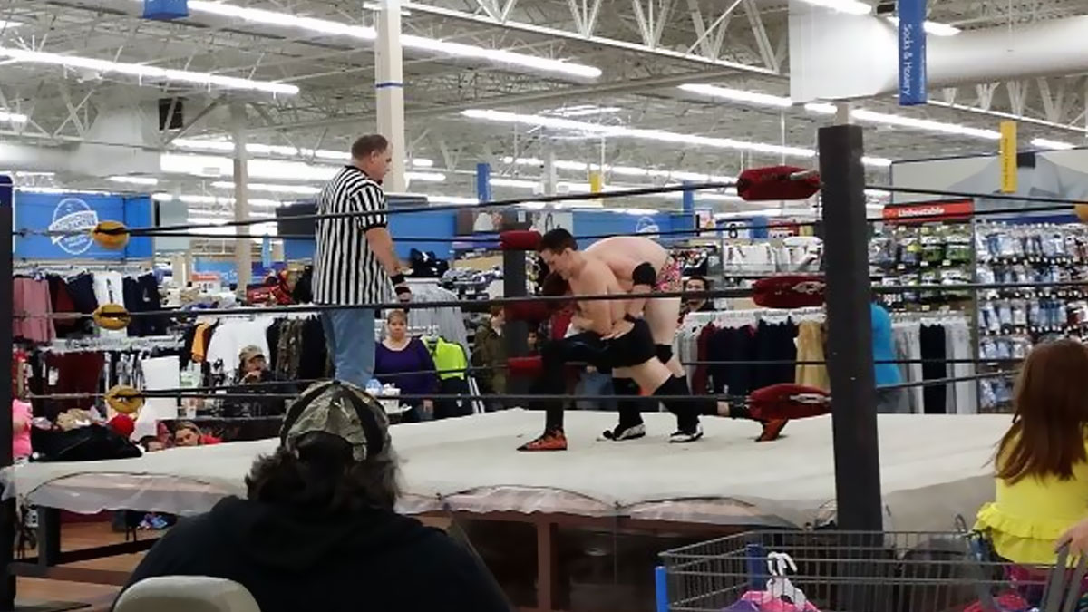 Luchadores en ring dentro de Walmart mientras compradores observan, imagen curiosa para fotos en Walmart.