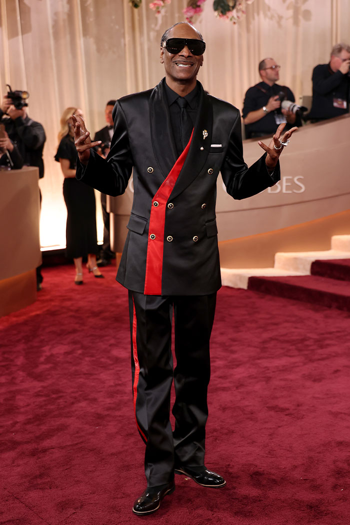 Hombre con traje negro y rojo en la alfombra roja mostrando un ejemplo de desastres de moda en los Globos de Oro 2026