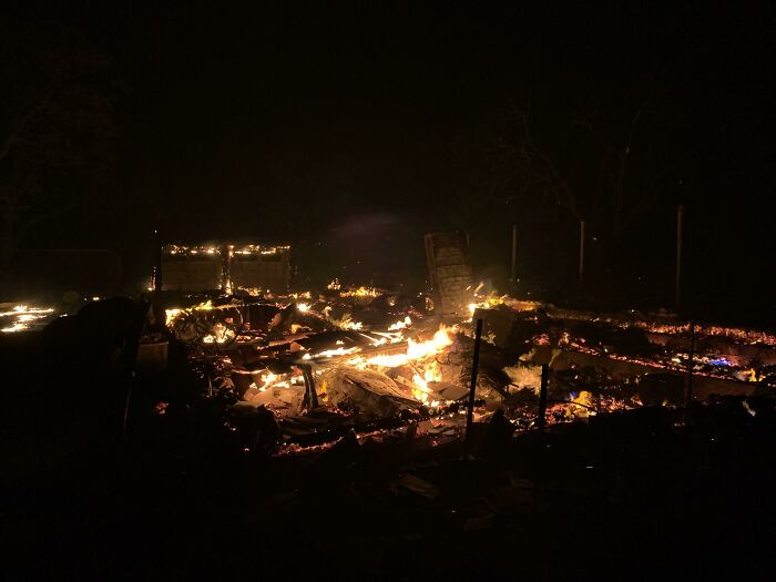 Restos en llamas de una estructura quemada durante la noche, mostrando un claro ejemplo de algo que salió mal.