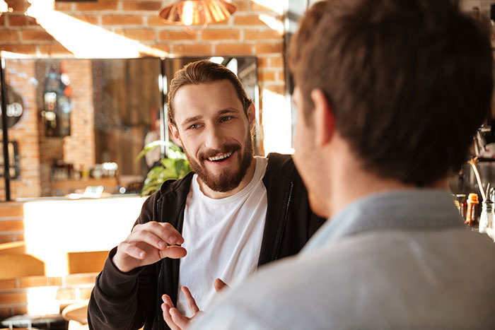 Dos hombres conversando animadamente en café, mostrando displays inquietantes de inteligencia y sorprendiendo con sus ideas.