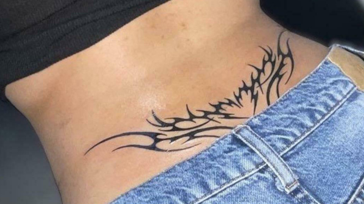 Tatuaje tribal en la piel junto a pantalones de mezclilla, foto de cosas que ya no existen que transportan al pasado.